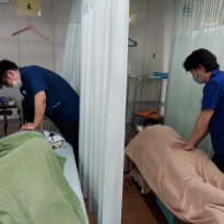 施術風景です。左の患者様は寝違い。右の患者様はぎっくり腰の施術中です。